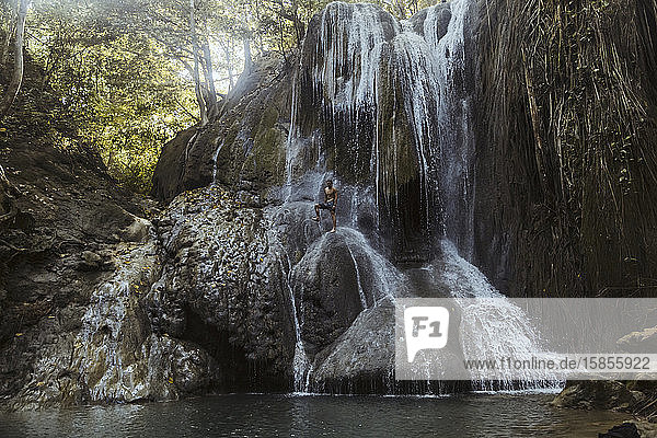 Mann klettert auf Wasserfall
