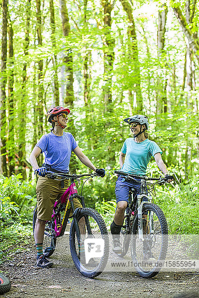Two female bikers enjoy a trail in Sandy  OR near Mt. Hood.