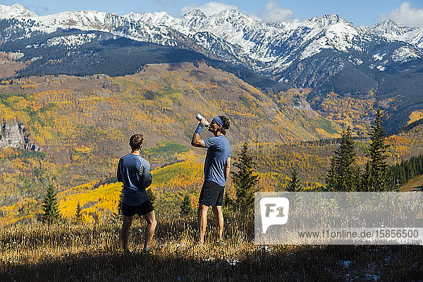 Men on trail run look at Gore Range mountains from Vail  Colorado