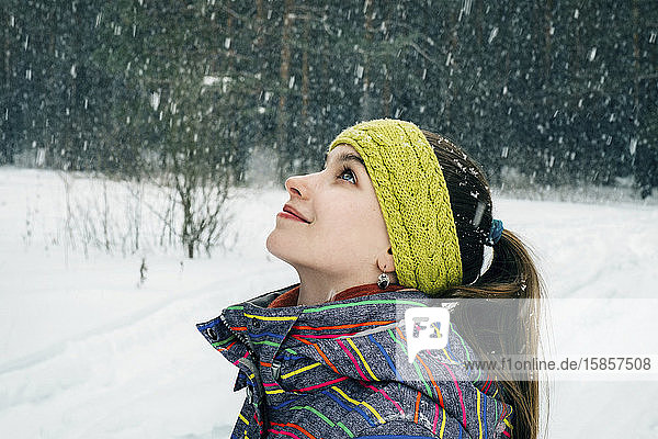 girl looks at snowflakes and smiles