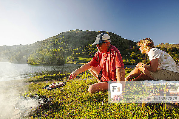 Ein Ehepaar beim Grillen an den Ufern des Rydal Water im Lake District  Großbritannien.