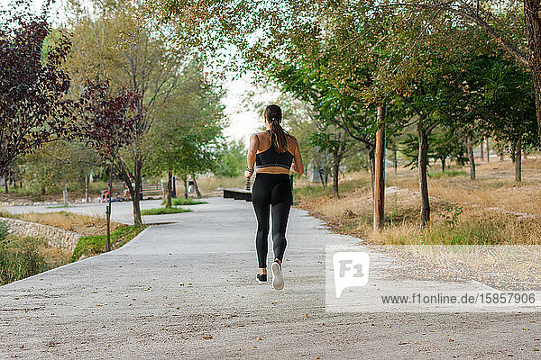Junge Frau läuft in einem Stadtpark. Weibliche Athletin  Sportkonzept.