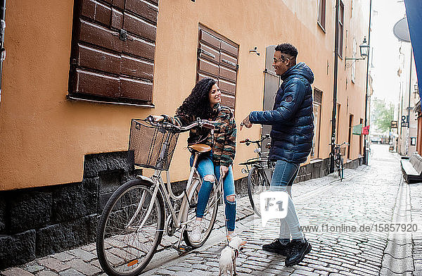 Mann und Frau auf den Straßen in Europa saßen auf einem Fahrrad und unterhielten sich