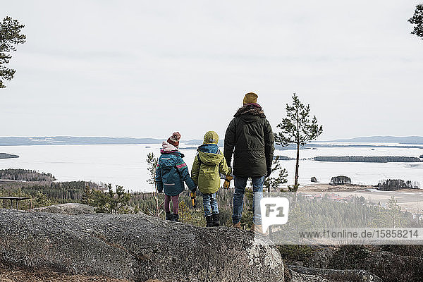 Vater und seine Kinder genießen eine schöne Küstenlandschaft in Schweden