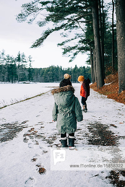 Two children leaving footprints in the snow.