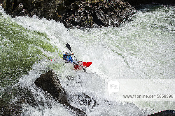 A whitewater kayaker paddles over a waterfall on the Callaghan Creek.
