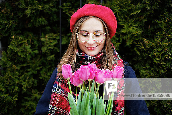 young french millennial girl in beret and coat with tulips in hands