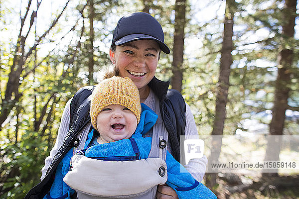 Porträt von Mutter und Tochter beim Spaziergang durch die Natur lächelnd.
