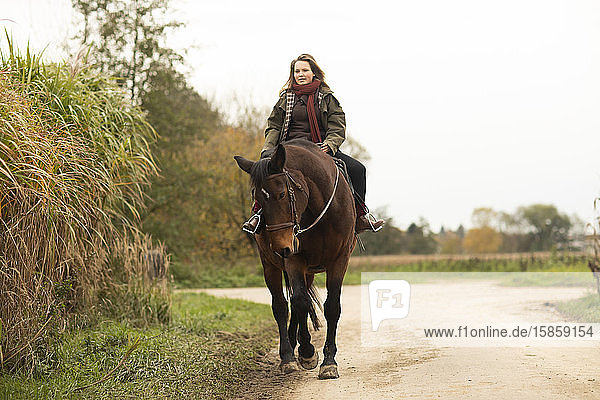 junge Reiterin mit einem Pferd beim Ausritt