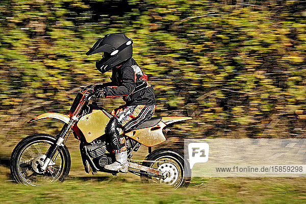12-jähriger Junge fährt mit seinem Motocross-Motorrad durchs Feld