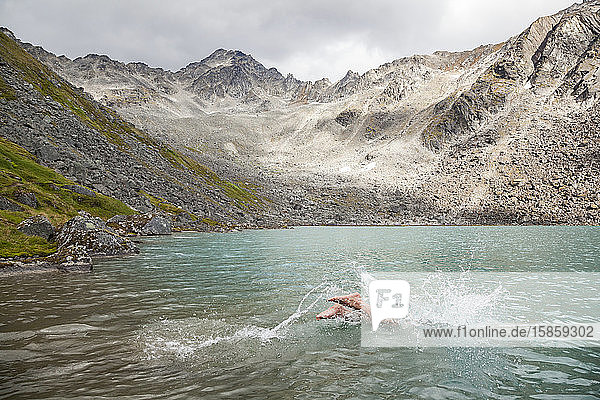 Man dives in for swim in Upper Reed Lake  Talkeetna Mountains  Alaska