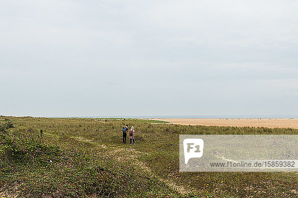 2 Menschen zu Fuß entlang der Küste von Norfolk