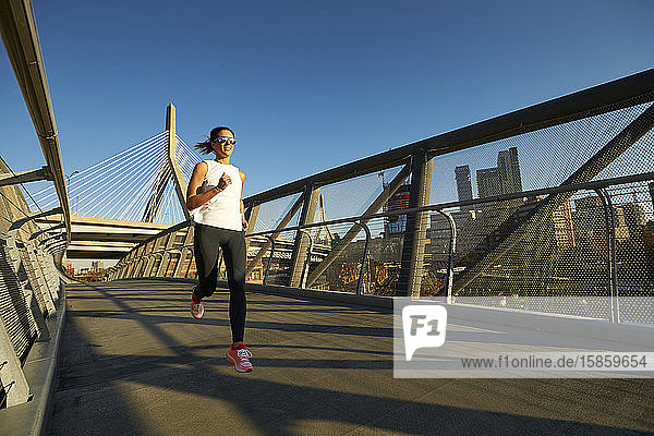 Ein Bostoner Läufer  der auf einer Fußgängerbrücke in der Nähe der Zakim-Brücke läuft.