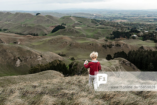 Young boy hiking through hillside in New Zealand