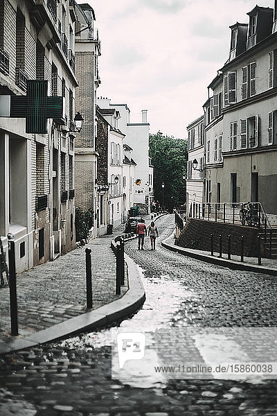 Menschen laufen bei bewölktem Himmel durch die Straßen von Paris