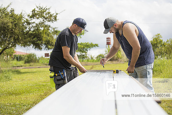 Zwei Männer bereiten eine Stahlexkursion für die Installation von Solarpaneelen vor.