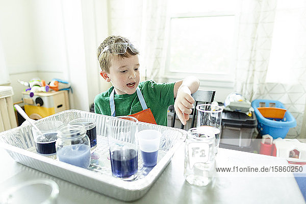 Junge macht wissenschaftliches Experiment  während er darauf zeigt und es erklärt