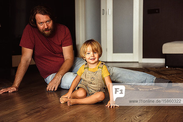 Vater mit kleinem Sohn spielt auf dem Boden