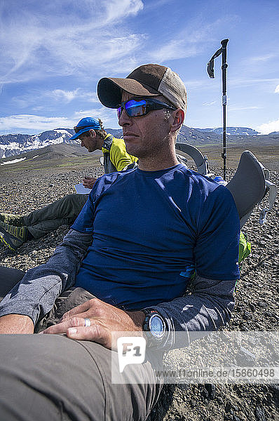 Two men pause for a break during hike in Alaska