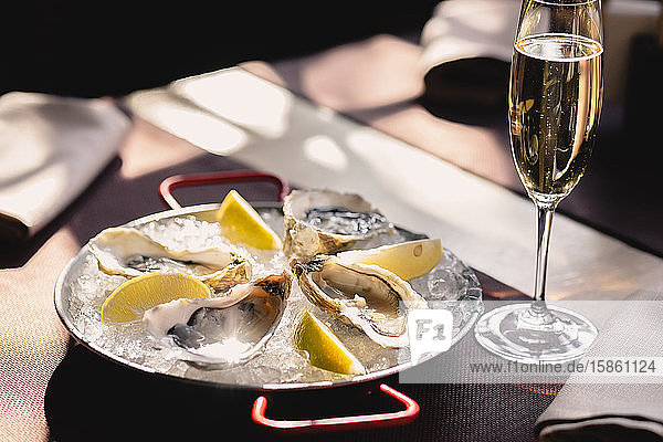Plate with oysters lemon and ice and a glass of champagne