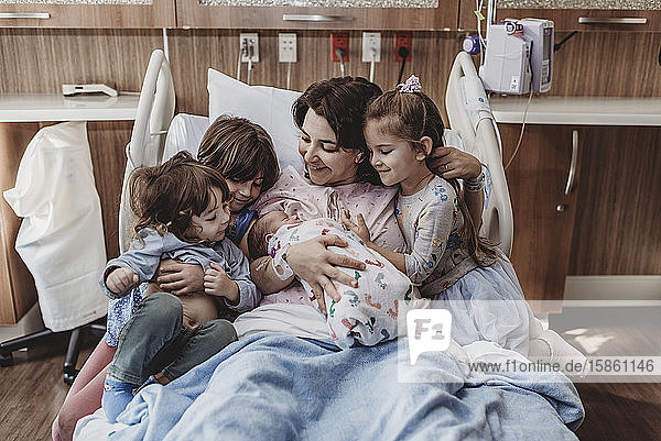 Mid view of mom and children holding newborn son