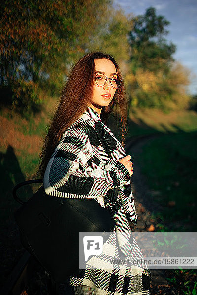 Herbstporträt einer jungen Frau mit Brille auf Natur