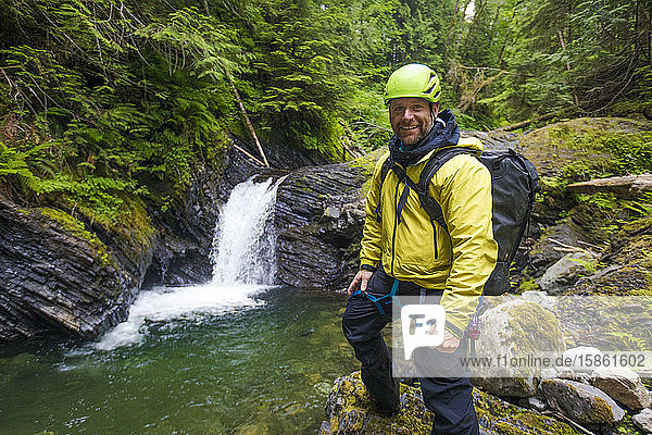 Portrait of hiker smiling  standing near waterfall.