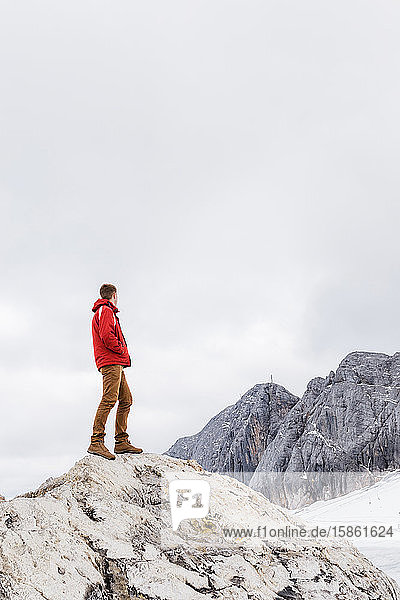 junger tausendjähriger Mann geniesst die Aussicht auf die Alpen auf einem Gletscher