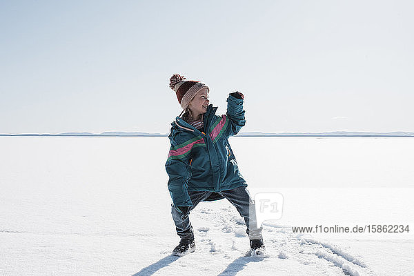 Mädchen tanzt auf einem zugefrorenen See in Schweden