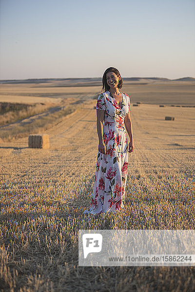 woman observing the dry field at sunset