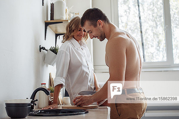 Young romantic couple on light modern kitchen.
