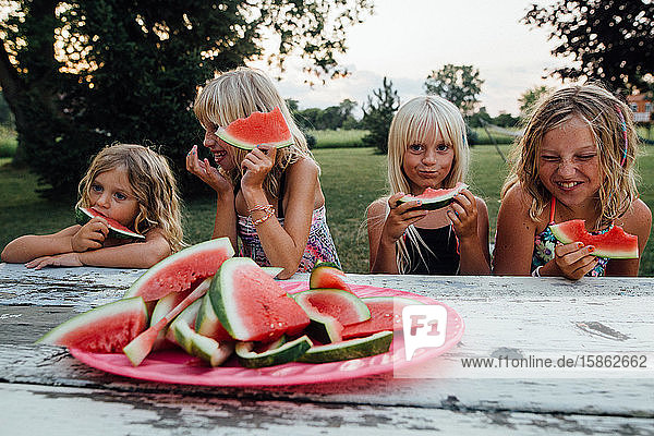 Geschwister haben im Sommer Spaß beim Wassermelonenessen im Freien