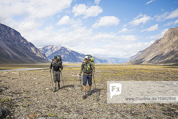 Two backpackers hiking in Akshayak Pass  Canada.