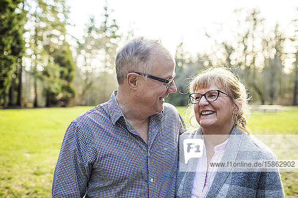 Ein süßes älteres Paar  das im Freien zusammen lacht und lächelt.