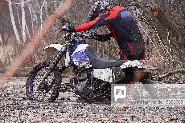 Mann fährt Motorrad im Dreck