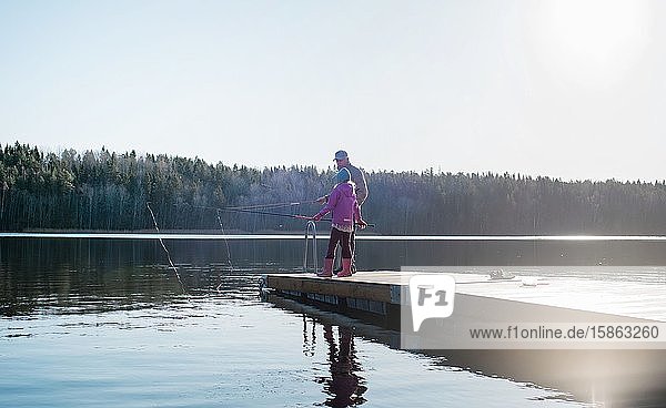 Großvater bringt seinem Enkel das Angeln in einem See in Schweden bei
