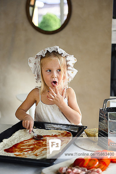Kleines Mädchen kocht Pizza in der Küche