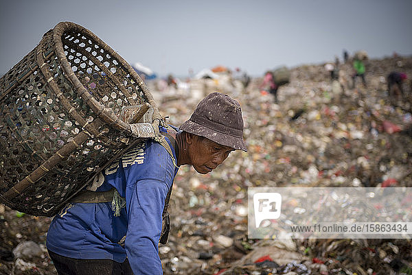 Ein Müllsammler geht auf der Deponie auf der Suche nach Materialien zur