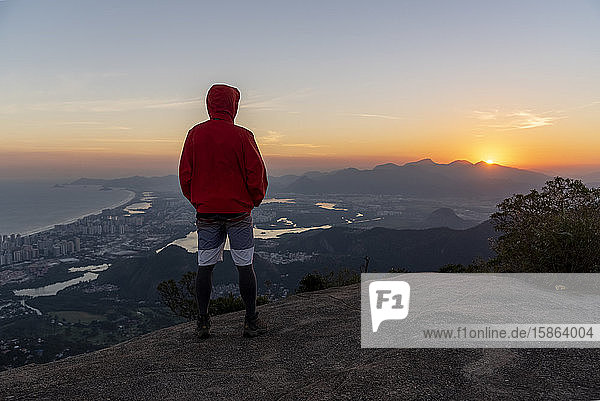 Beautiful landscape of man looking at the sunset from mountain top