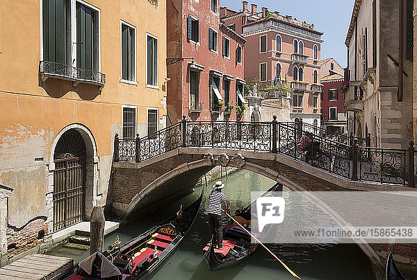 Gondel  die unter einer Brücke über einen kleinen Kanal fährt  Venedig  UNESCO-Weltkulturerbe  Venetien  Italien  Europa