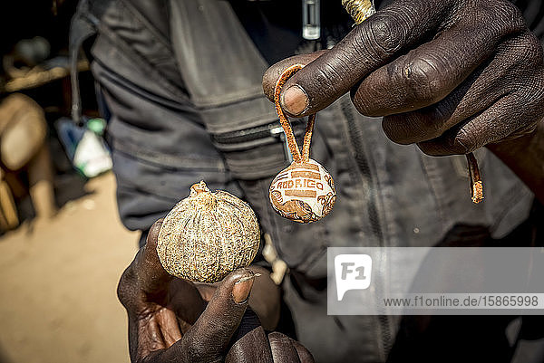 Man holds an item to sell at the Okahandja Mbangura Woodcarvers Craft Market; Okahandja Otjozondjupa Region Namibia