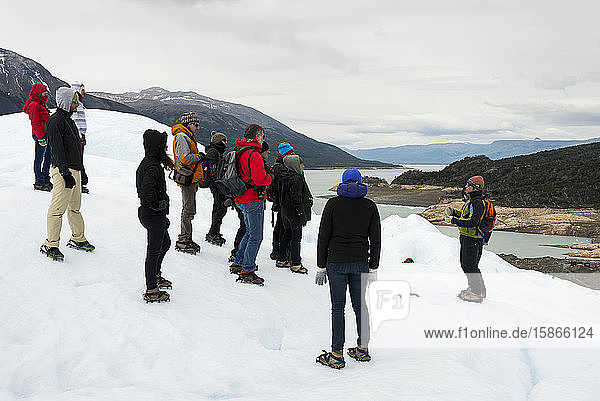 Touristen hören einem Führer zu  während sie auf einem Gletscher im Los Glaciares National Park stehen; Provinz Santa Cruz  Argentinien