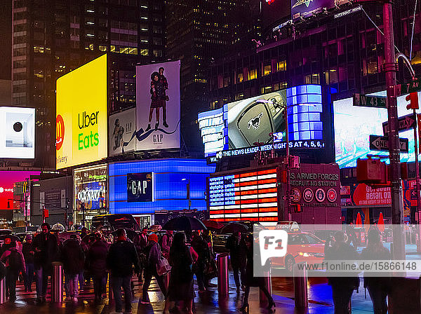 Times Square advertisements illuminated at night with tourists lining the street Midtown Manhattan; New York City New York United States of America