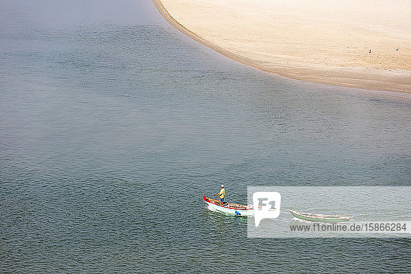 Fisherman standing in a boat off the beach; Lang Co Thua Thien-Hue Province Vietnam