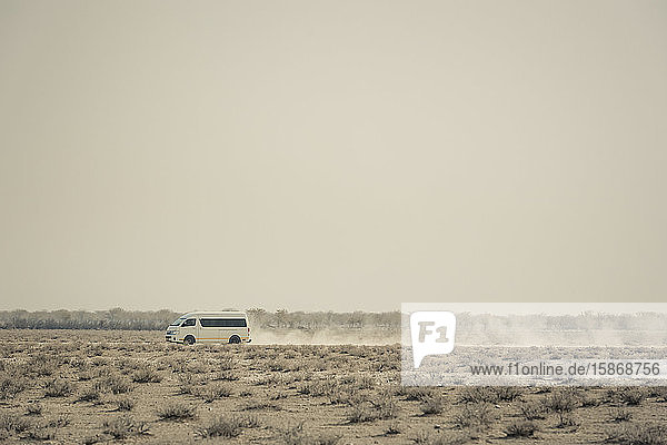 Ein Fahrzeug auf einer staubigen Straße  Etosha-Nationalpark; Namibia