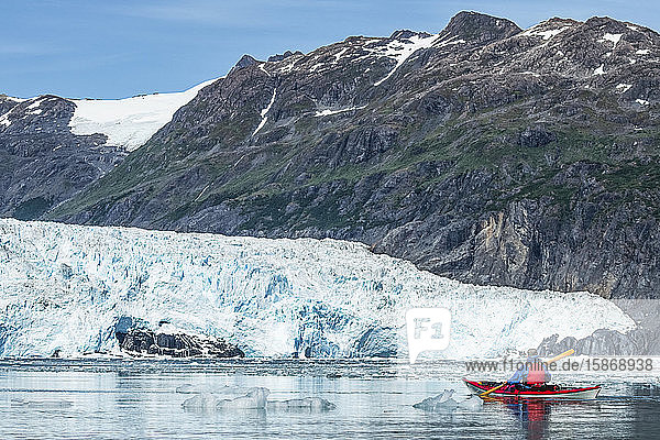 Kayaker paddling in front of a tidewater glacier in Prince William Sound; Alaska  United States of America