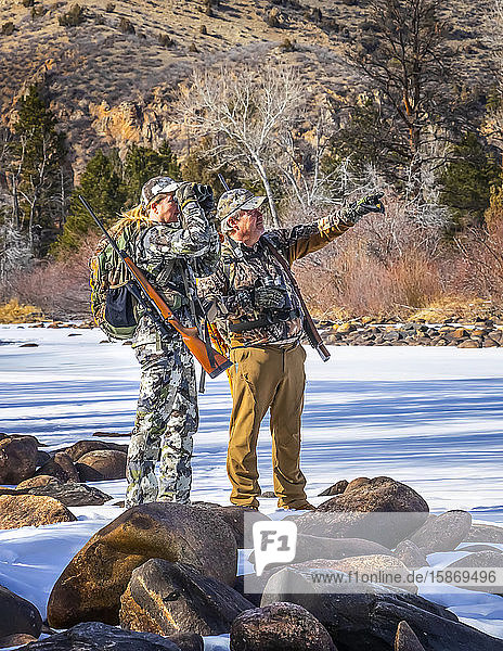 Jäger mit Tarnkleidung und Gewehr  die mit einem Fernglas hinausschauen; Denver  Colorado  Vereinigte Staaten von Amerika