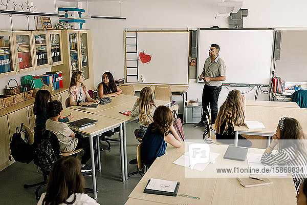 Männlicher Tutor unterrichtet Studenten im Klassenzimmer