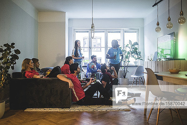 Männliche und weibliche Fans sehen Fußballspiele im Wohnzimmer