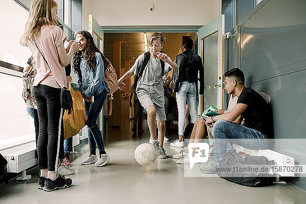 Male and female school students in corridor during lunch break